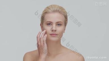 年轻、美丽、自然的金发女子应用护肤霜的工作室<strong>肖像</strong>。 面部整容、化妆品及化妆.
